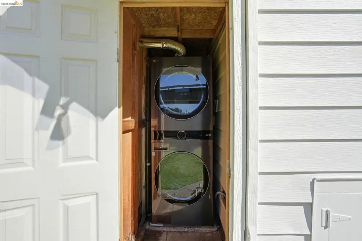 Laundry area with stacked washer and dryer