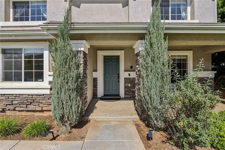 Welcoming front entry includes a covered porch with stone accents and a walkway leading to the front door