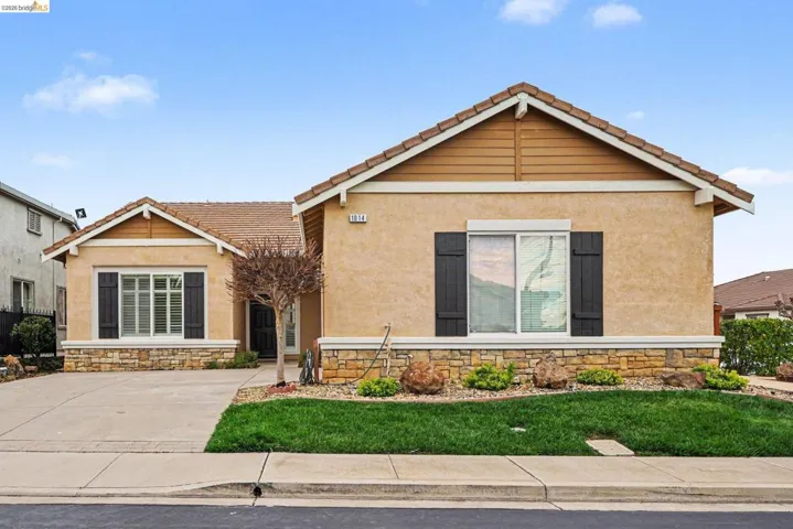 View of front of house with stone siding, stucco siding, and a tile roof