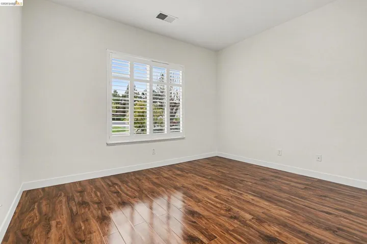 Empty room with dark wood-style flooring and baseboards