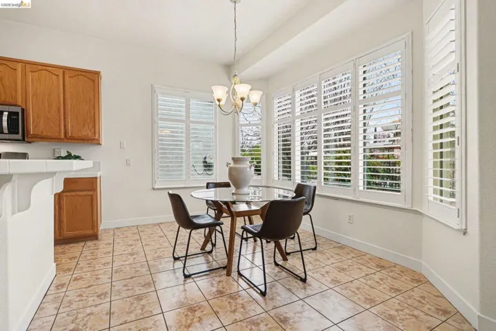 Dining room with light tile patterned floors and hanging lights