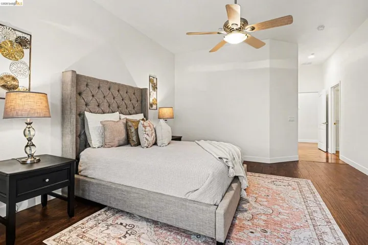 Bedroom with dark wood-type flooring and ceiling fan