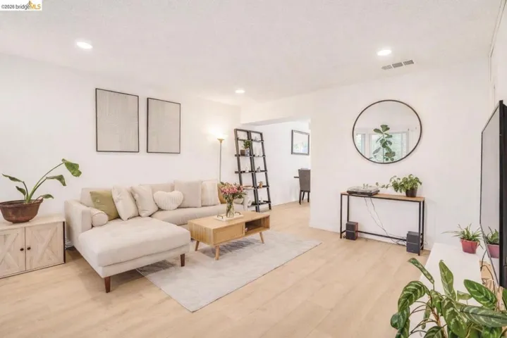 Living area featuring light wood finished floors and recessed lighting