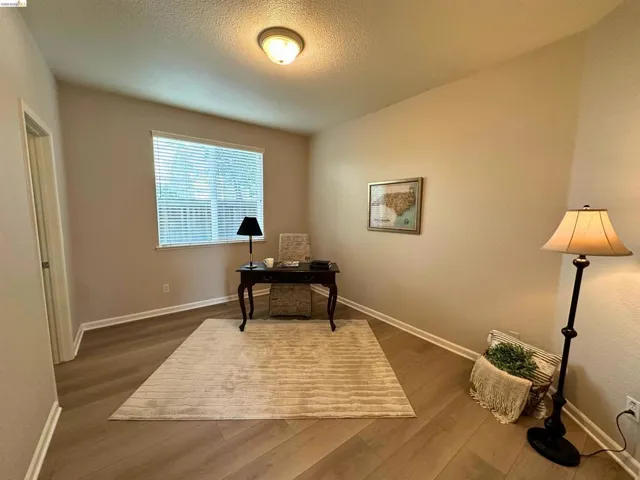 Office with dark wood-type flooring and a textured ceiling