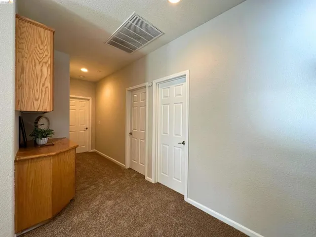 Hallway featuring dark carpet and recessed lighting