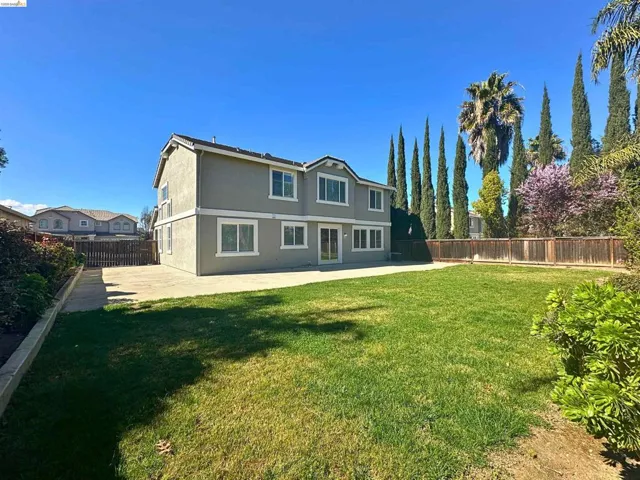Back of house with a fenced backyard, stucco siding, and a patio