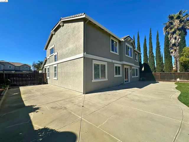 Rear view of property featuring a fenced backyard and stucco siding