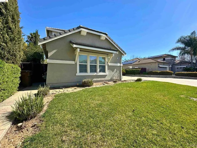 View of front facade featuring a front lawn and stucco siding