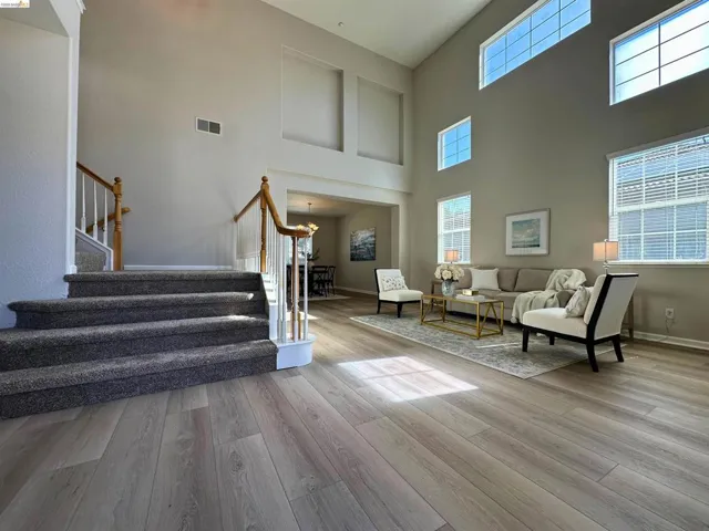 Living room with light wood finished floors and a high ceiling