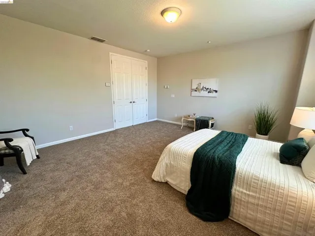 Bedroom with dark carpet and baseboards
