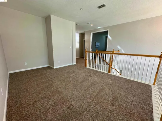 Unfurnished room with dark carpet and a textured ceiling