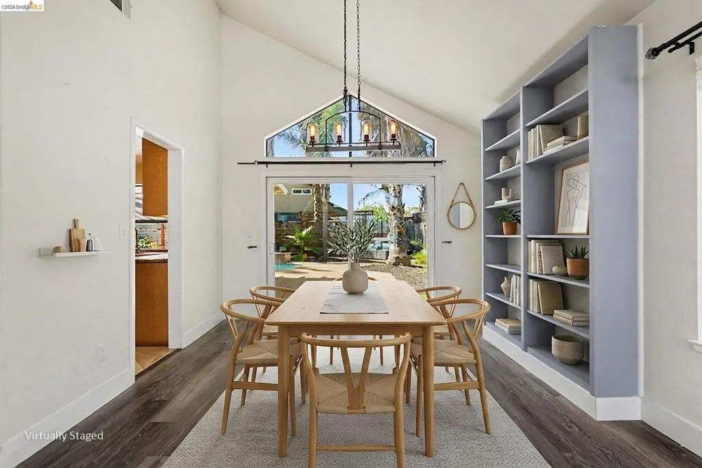 Dining area with vaulted ceiling and wood-finish flooring