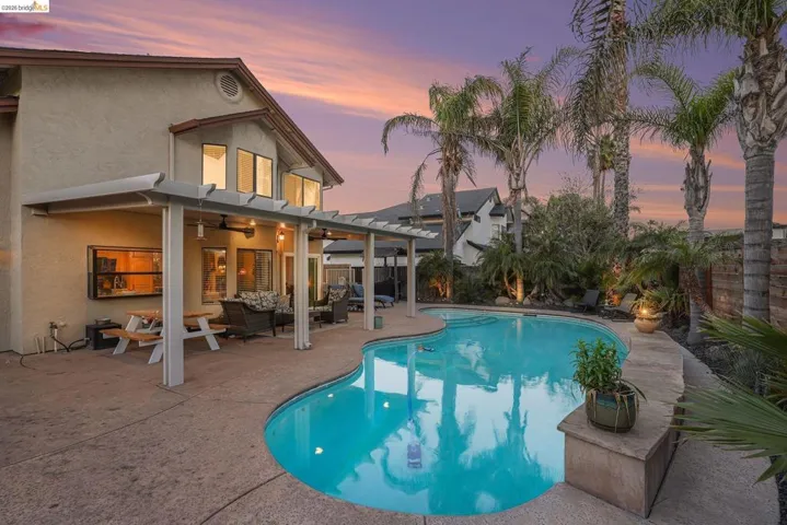 View of swimming pool with a pergola, patio surround, a fenced backyard, and an outdoor hangout area