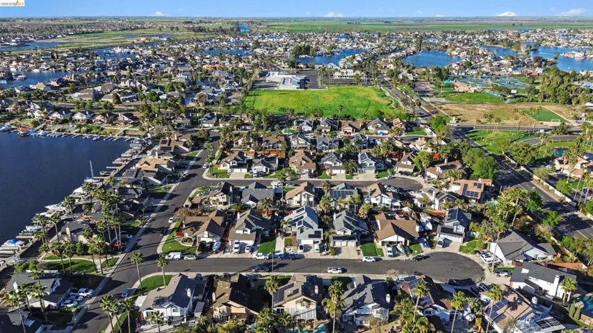 Aerial overview of property's location with a large body of water and nearby suburban area