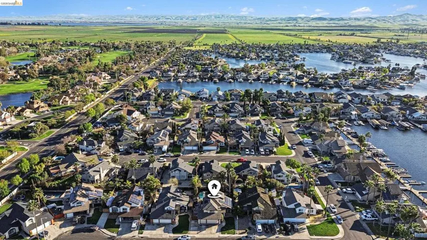 Aerial perspective of suburban area featuring a nearby body of water
