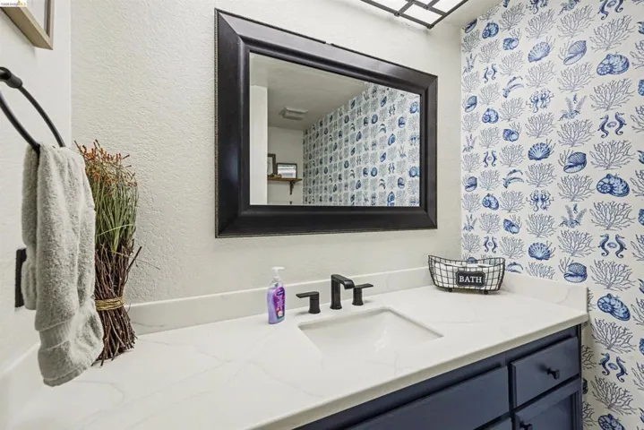 Bathroom featuring vanity and a textured wall