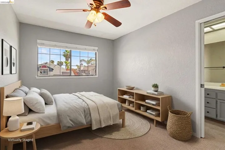 Bright room with a large window, neutral carpeting, and a ceiling fan with integrated lighting