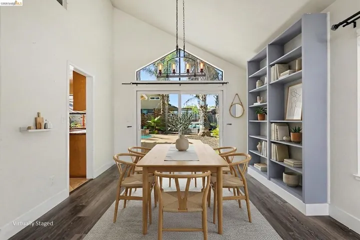 Dining area with vaulted ceiling and wood-finish flooring