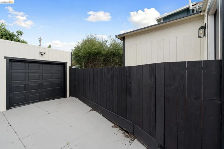 View of property exterior featuring concrete driveway