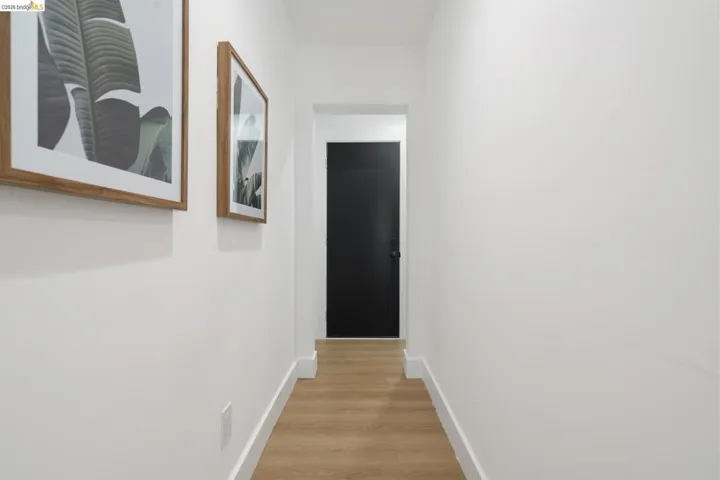 Corridor featuring light wood finished floors and baseboards