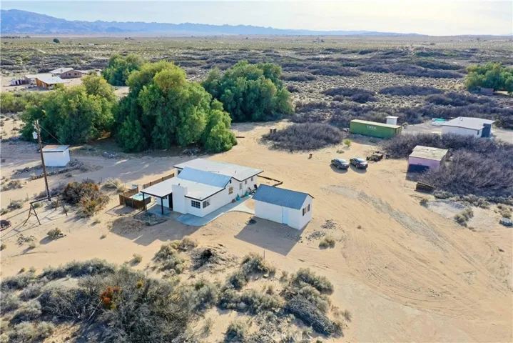corner lot nestled within mature mesquite trees, offering rare natural privacy and character. This property sits on generous acreage with expansive 360° desert and mountain views in every direction. The setting provides a unique blend of open space and established greenery—something you don’t often find in the high desert. Includes paid-off solar, adding long-term efficiency and value.