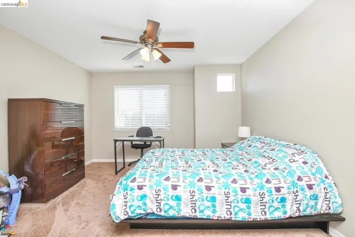 bedroom with light carpet and a ceiling fan