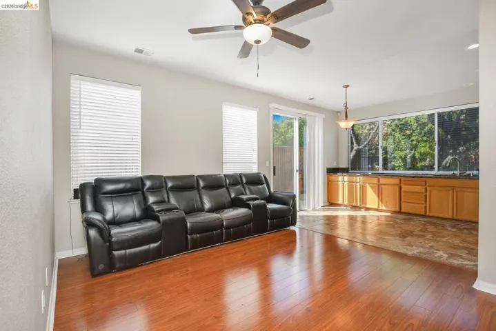 living area with ceiling fan and dark wood-type flooring