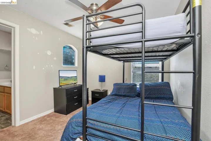 carpeted bedroom with a ceiling fan and baseboards