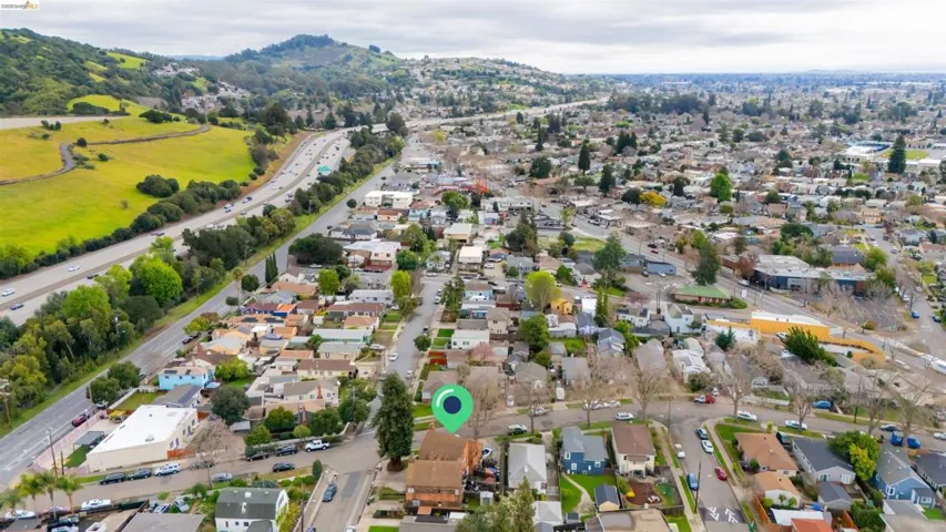 Aerial view of property's location with nearby suburban area and a mountainous background