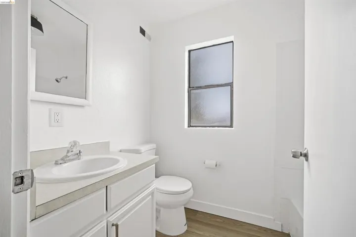 Bathroom featuring vanity, light wood-type flooring, and a shower