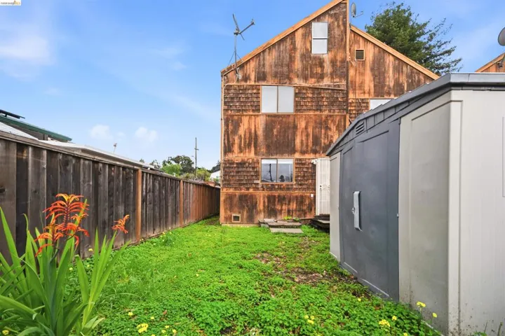 Rear view of property featuring a fenced backyard and a storage unit