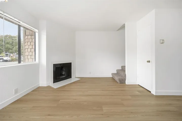 Unfurnished living room featuring light wood-style floors and a fireplace with flush hearth