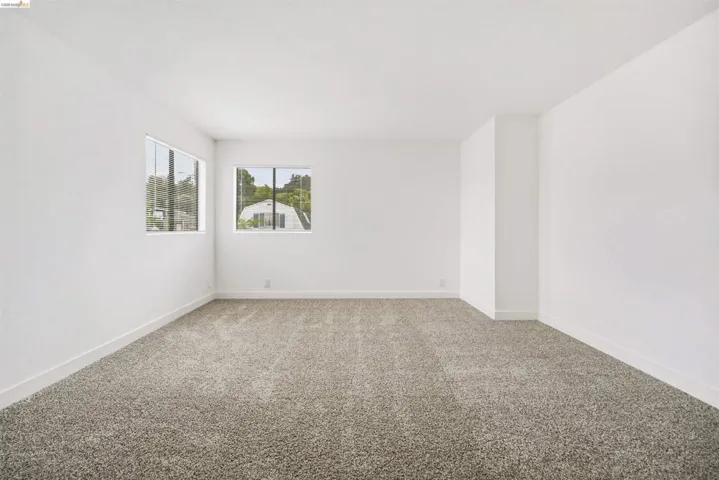 Spare room featuring carpet flooring and baseboards
