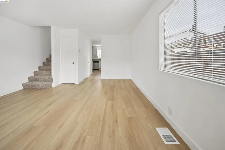 Unfurnished living room with stairs and light wood-style floors