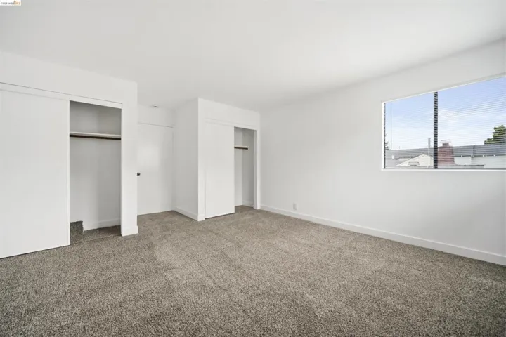 Unfurnished bedroom featuring two closets and carpet flooring