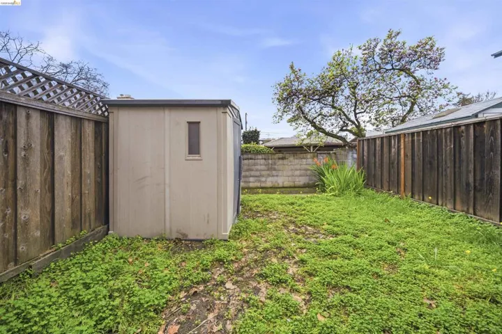 Fenced backyard featuring a storage shed