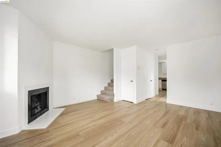 Unfurnished living room featuring a tile fireplace and light wood-style floors