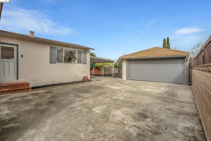 View of property exterior with a detached garage, an outbuilding, and stucco siding
