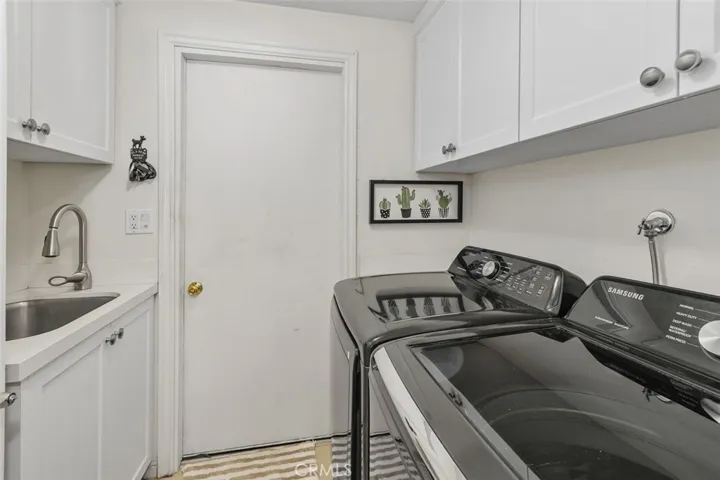 laundry room with soaking sink and plenty of cabinet storage.