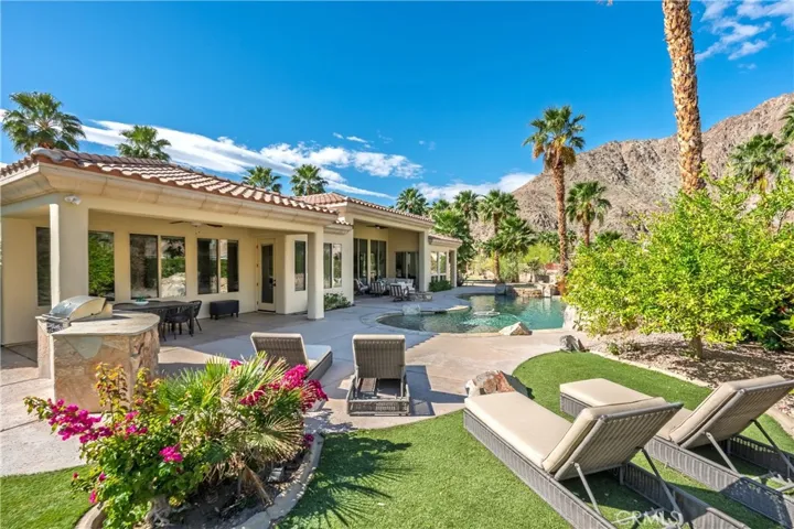 Outdoor entertaining begins with a built-in barbecue and multiple lounge areas surrounding the pool.