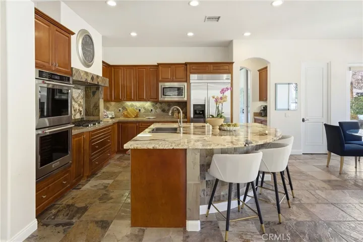 Well-appointed with KitchenAid double ovens, a built-in refrigerator, five-burner range, walk-in pantry, and a butler’s pantry connecting the kitchen to the formal dining and living areas.