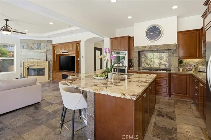 The kitchen opens seamlessly to the family room and fireplace, creating an inviting space for gathering and entertaining.