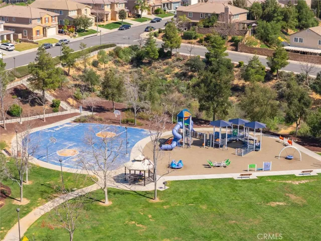 Large community park with basketball courts, playground and green grass