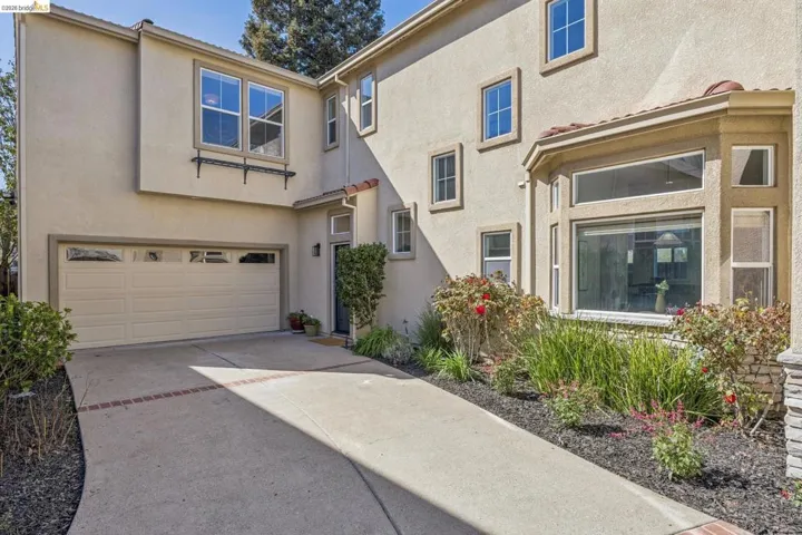 View of front facade featuring stucco siding, a garage, and concrete driveway