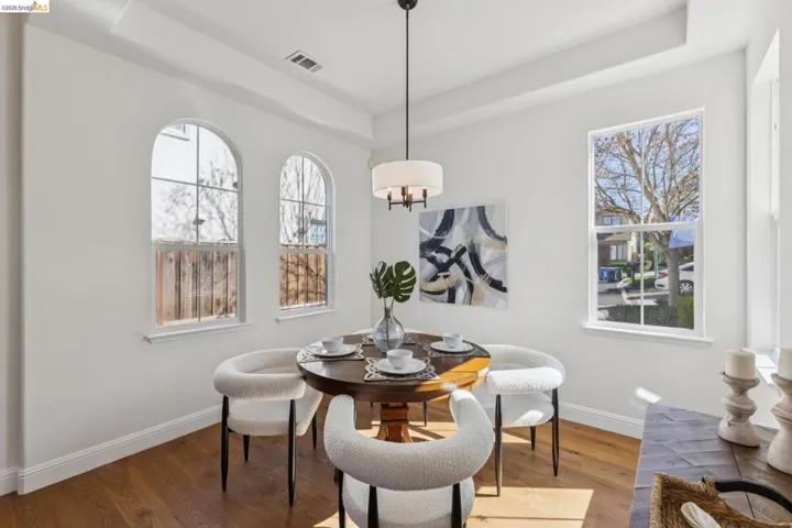 Dining space with a tray ceiling and wood finished floors