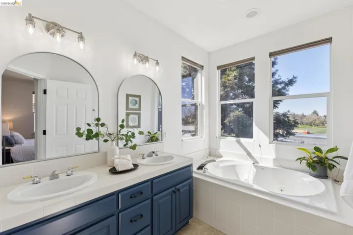 Ensuite bathroom with double vanity and a tub with jets
