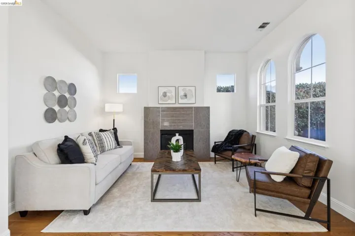 Living room with light wood-type flooring and a tiled fireplace