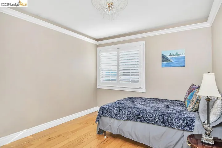Bedroom featuring light wood-style floors and ornamental molding