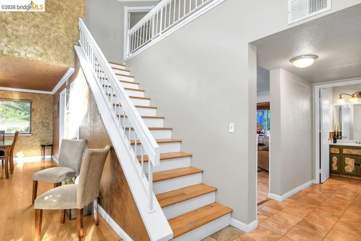 Staircase featuring a textured ceiling and ornamental molding