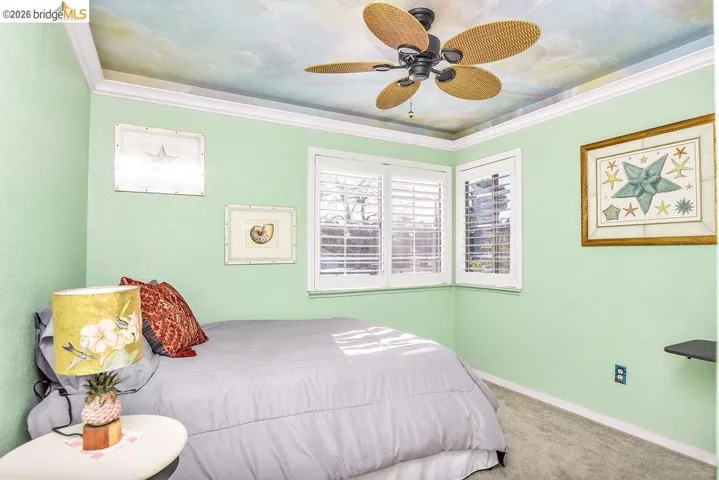 Bedroom featuring carpet floors, crown molding, and a ceiling fan